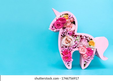 Children's Bouquet In The Form Of A Unicorn On A Blue Background. Creative Floristry. Flowers In Soft Pink Colors. The Picture In The Style Of Minimalism. 