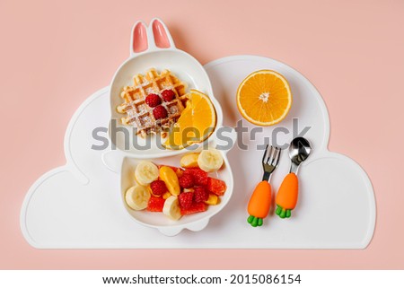 Children's Breakfast. Cute plate in the shape of a bunny with waffles and fruits. Food idea for kids.