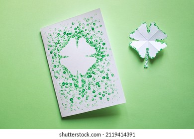children's card DIY for St. Patrick's Day. four-leaf clover with spots of green paint. art craft for kids