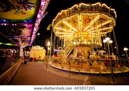 Children's Carousel at an amusement park in the evening and night illumination. amusement park at night. amusement park, picture for the background.