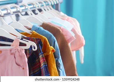 Children's cloth rack, selective focus. Pastel color children's  clothes in a Row on Open Hanger indoors. Clothes for little ladies hung in the children's room.
Turquoise and pastel pink colors. - Powered by Shutterstock