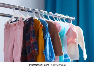 Children's cloth rack, selective focus. Pastel color children's  clothes in a Row on Open Hanger indoors. Clothes for little ladies hung in the children's room.
Turquoise and pastel pink colors. - Powered by Shutterstock