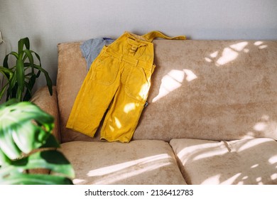  Children's Clothing Yellow Jumpsuit And T-shirt Lie On The Sofa.