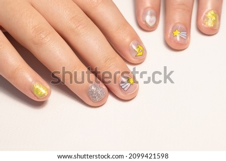 Children's colored manicure with stickers. Manicure for girls with ordinary varnish. Hypoallergenic nail polish for children. Fashionable manicure with stickers. 