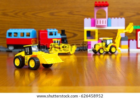 Children's construction equipment is yellow in the background of a toy building macro