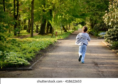 Children's Day.  Little Boy Running In The Park. Back View