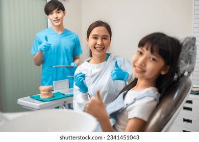 Children's dentistry for healthy teeth .Close-up  happy little child asian girl smiles looking at camera, sitting in dentist's chair, receiving dental. - Powered by Shutterstock