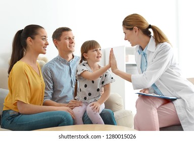 Children's doctor visiting little girl with parents at home. House call - Powered by Shutterstock