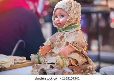 Children's doll dressed in pancakes in the form of fur coats, Decorations in the city for the Maslenitsa holiday in Moscow - Powered by Shutterstock