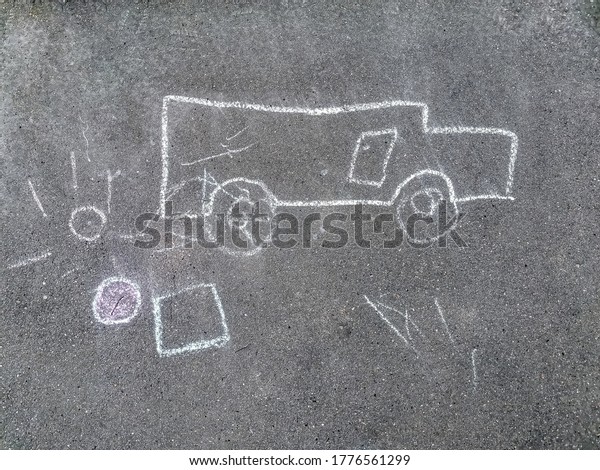 Children\'s drawing with chalk on the pavement. The\
child painted a white chalk car and the sun on the sidewalk.\
Concept: childhood, creativity,\
walks.