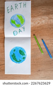 Children's drawing of the planet Earth with a world map with multi-colored pencils and felt-tip pens on white paper. The concept of the day of peace and earth, environmental protection.
