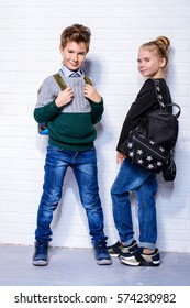Children's fashion. Modern boy and girl posing together at studio. Education.