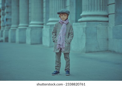 Children's fashion. Retro style. Portrait of little boy in a retro style coat and cap standing on the street with his hands in his pockets. Full length shot. - Shutterstock ID 2338820761