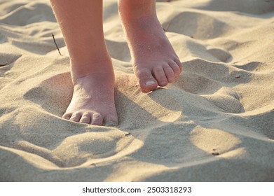 children's feet on the sandy seashore. summer vacation, tan. background for the design. - Powered by Shutterstock