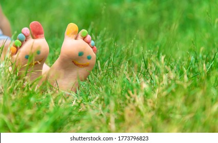 Children's feet with a pattern of paints smile on the green grass. Selective focus. nature. - Shutterstock ID 1773796823