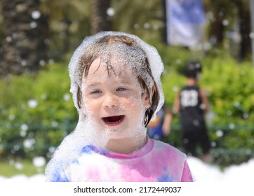 Children's foam party. The boy plays in the foam. Concept: birthday, animators, party.