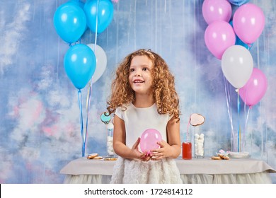 La fiesta de cumpleaños divertida de los niños en la habitación decorada. Niña feliz celebra el Día Internacional del Niño. Juego infantil divertido en casa