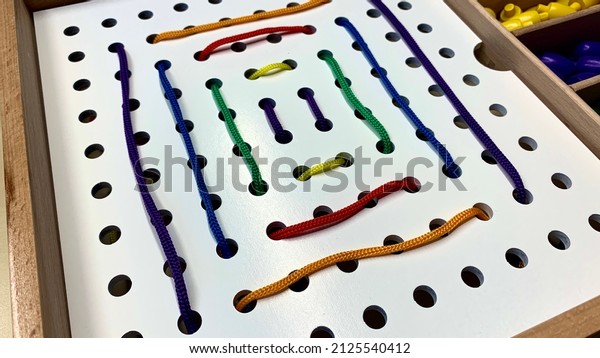 Children's game for the development
of fine motor skills with colored laces and holes for
tying