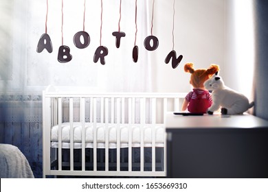 Children's gloomy room with an empty cradle and toys on the dresser. The inscription in cartoon font Abortion. Concept of abortion and female infertility