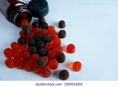 Children's Gummy Vitamins On A White Background With A Bottle.	