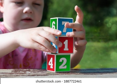 Children's Hands Build A Tower Of Learning Blocks With Numbers. Initial Training In Counting. Foundations Of Mathematics.