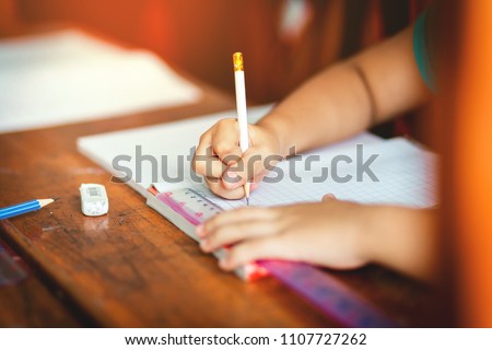 Children's hands are doing their homework.