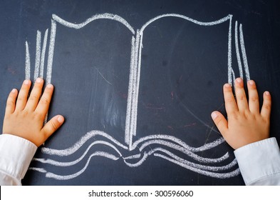 Childrens Hands Holding A Book Drawing On The Board. The Toning. Selective Focus