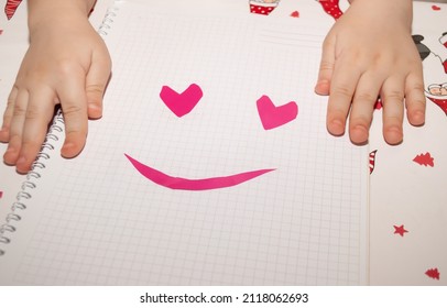 children's hands lie on white paper smiley hearts. craft of a child to dnb valentine valentine's day in kindergarten school