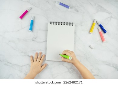 Children's hands make crafts, draw and write in a notebook. A blank page, copy space for text. Children's art project. The concept of DIY, online education and workshops. Office, markers - Powered by Shutterstock