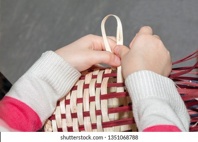 Children's hands make a wicker basket in a needlework class. wicker weaving