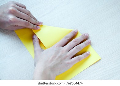 Children's Hands Make Of A Yellow Paper Boat