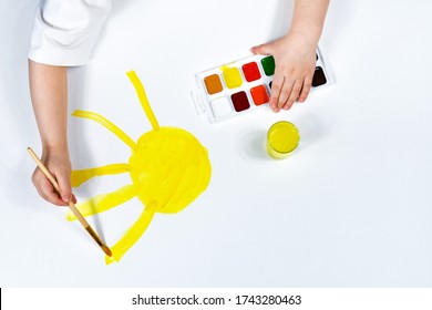 Children's hands are painted with a brush and watercolors. Children's creativity, painting, early development.