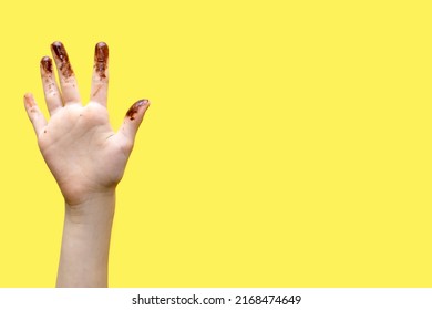 Children's hands smeared in chocolate on a yellow background. The concept of love for sweets and free space for text between hands