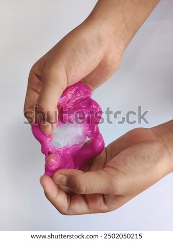 children's hands squeezing or playing with very fun and cute elastic slime on an isolated white background. Children playing with slime