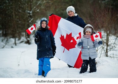 Childrens Holding Flag Of Canada On Winter Landscape.