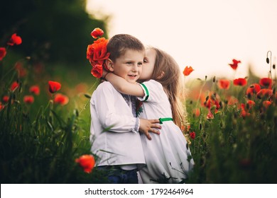 Children's Love, A Little Boy And A Girl, Amicably Spend Time, Laugh And Smile, And Kiss In The Flowering Field Of Poppies