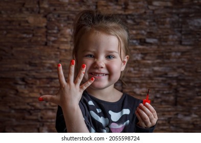 Children's manicure with red nails for Halloween. Halloween concept. A girl in a skeleton costume painted her nails for the holiday. Horizontal photo.
