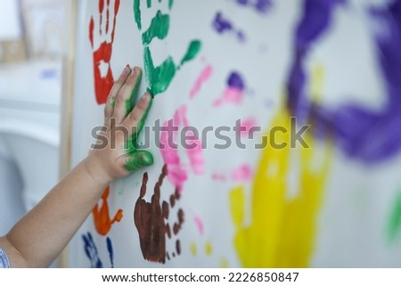 Children's master class in drawing, the child makes a handprint with paint.