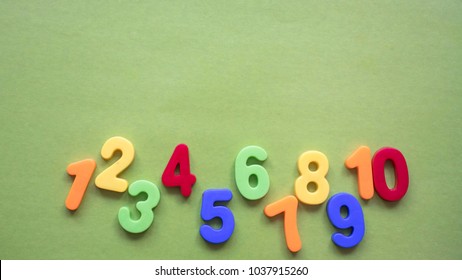 children's multi-colored numbers on a green background, copy space