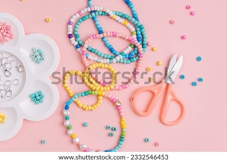 Children's needlework and beading. Handmade bracelets and different beads for children's crafts. DIY art activity for kids. Motor skills, creativity and hobby.