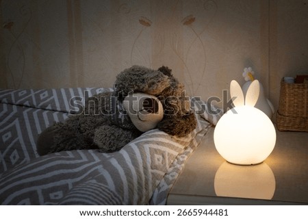 Children's night light in the shape of a hare on a nightstand.