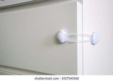 Children's Plastic Stopper On The Chest Of Drawers. Children's Lock For Furniture Boxes, Refrigerator. Providing A Safe Space For Children.