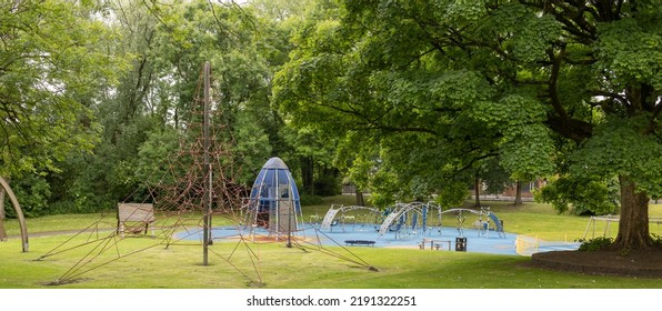 Childrens Play Equipment In A Local Park, Green Trees And Grass, No People