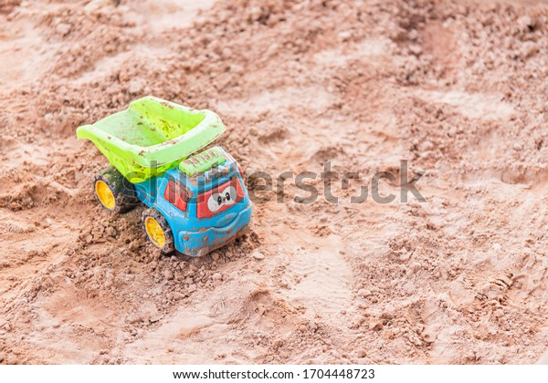 Children\'s\
playground with empty sandbox and abandoned colorful toy car.\
Relaxation park, leisure place for families and children.\
Coronavirus. Quarantine, kids are at\
home.