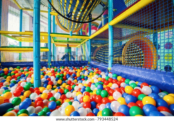 Children\'s\
playground indoor, inside plastic structure for active games and\
development of motor skills. Large dry pool, ball pit in playroom.\
Kids gym, colorful playground in\
kindergarten.