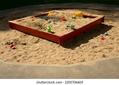 Children's playground with sand. Children's sandbox on street. Place for game kids. Sand with toys. Forgotten toys.