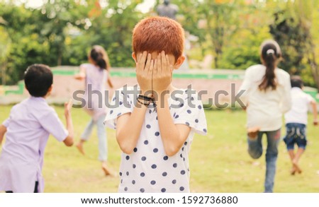 Childrens playing hide and seek at park - Multi ethnic kids playing outdoor games.