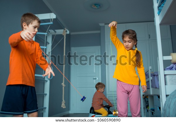 Childrens playing\
with yo-yo toy. Home\
plays.