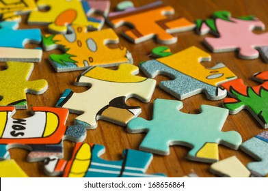 Children's puzzle scattered on a wooden table - Shutterstock ID 168656864