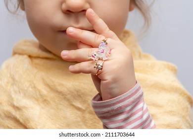 Children's Rings And Jewelry On The Fingers Of A Little Girl, Selective Focus.  A Young Fashionista Shows Her Jewelry.